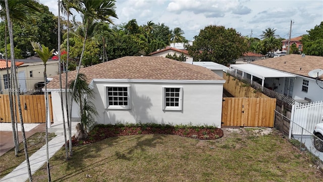 view of property exterior with a gate, stucco siding, roof with shingles, and fence