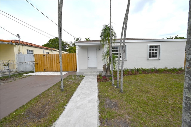 view of front facade featuring a front yard, fence, and stucco siding