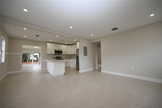 unfurnished living room with visible vents, recessed lighting, and baseboards