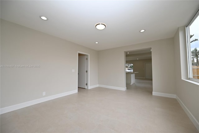 unfurnished room with recessed lighting and baseboards