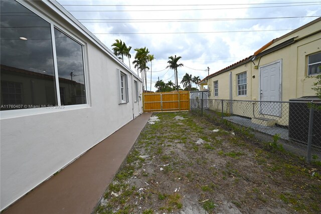 view of front of house with stucco siding, fence, a front lawn, and a gate