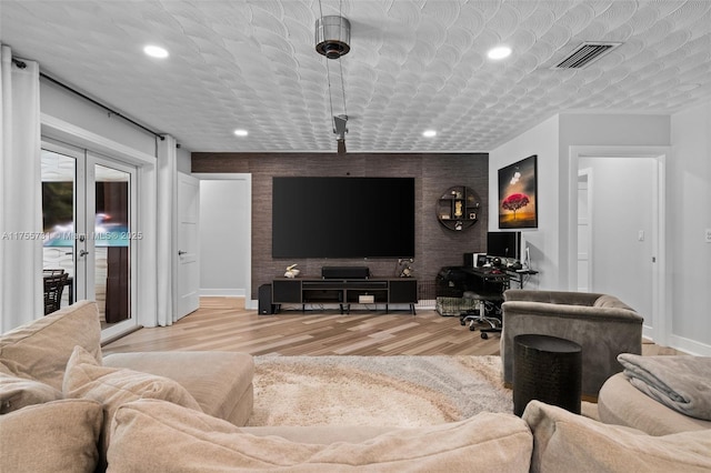 living room with visible vents, an accent wall, baseboards, recessed lighting, and wood finished floors