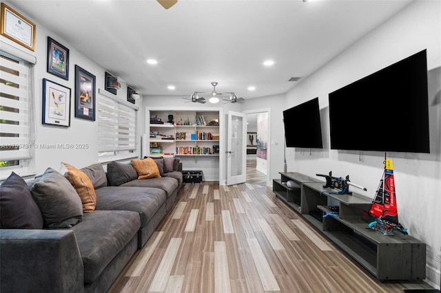 living area with light wood finished floors, visible vents, recessed lighting, and a ceiling fan