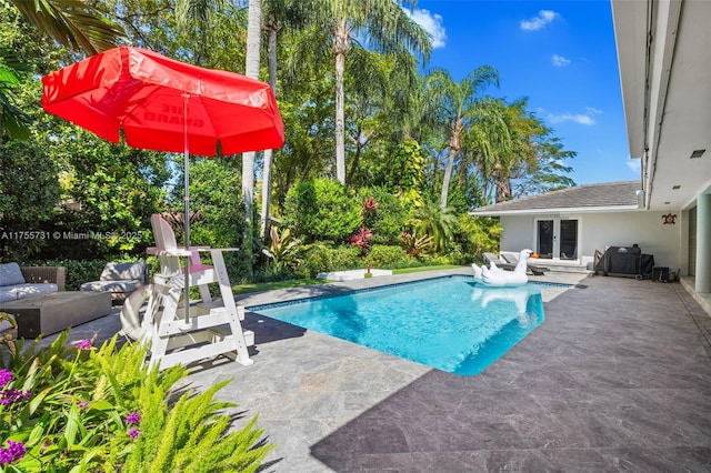pool featuring an outdoor living space, french doors, and a patio area