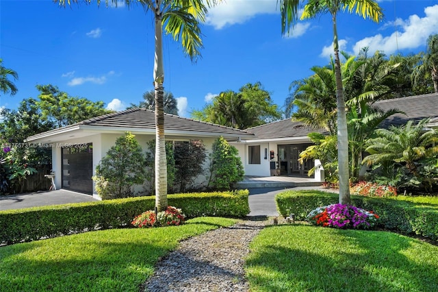 view of front of house featuring a front lawn, stucco siding, and a tiled roof