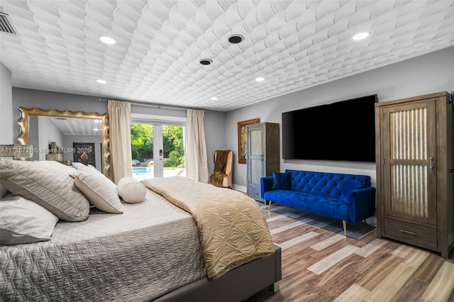 bedroom with recessed lighting, wood finished floors, access to outside, and french doors