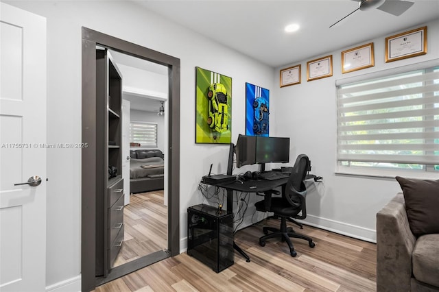 office space featuring baseboards, wood finished floors, and a ceiling fan