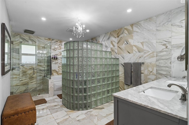 bathroom featuring recessed lighting, a shower stall, double vanity, tile walls, and a sink