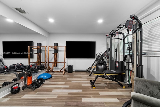 exercise area with wood finished floors, recessed lighting, and visible vents