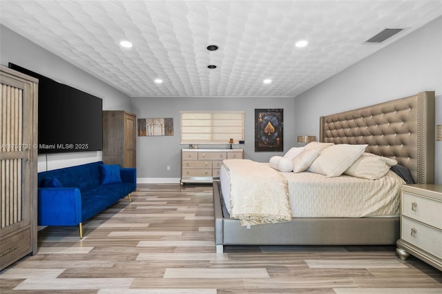 bedroom featuring baseboards, visible vents, light wood finished floors, and recessed lighting