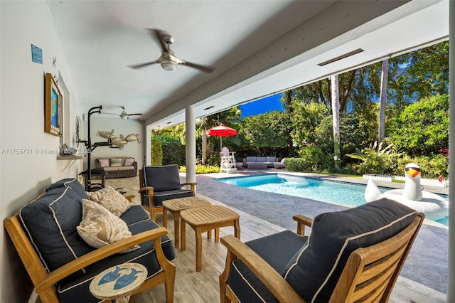 outdoor pool featuring a patio, a ceiling fan, and an outdoor hangout area