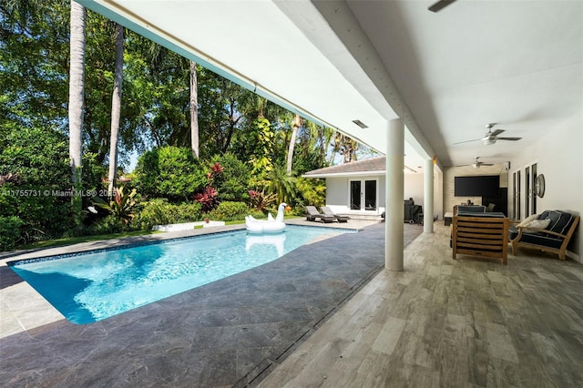 pool with a patio area, an outdoor living space, french doors, and a ceiling fan