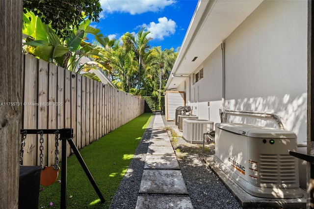 view of yard with central AC unit and fence