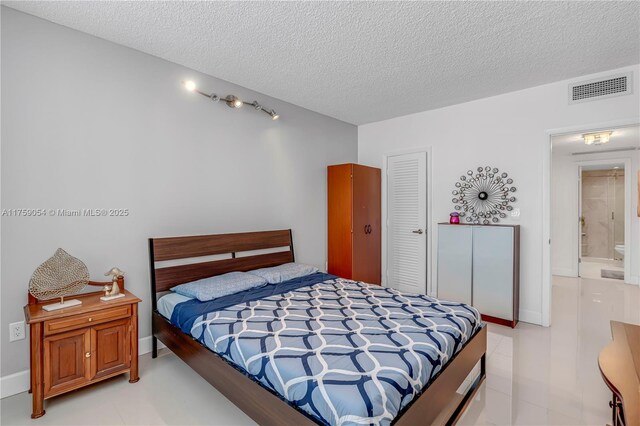 bedroom with a textured ceiling, a closet, and baseboards