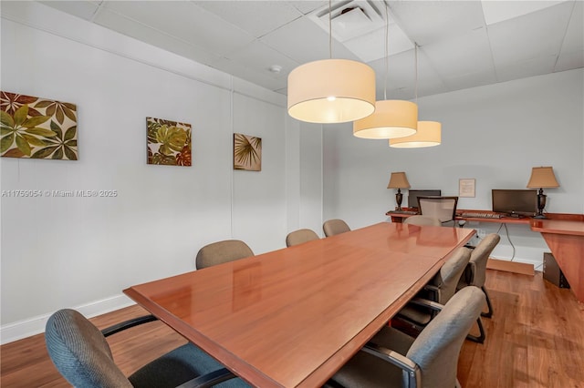 dining area with visible vents, baseboards, and wood finished floors