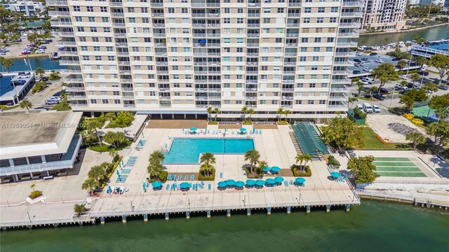 aerial view of apartment complex, a large body of water, and a pool area