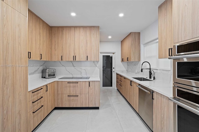 kitchen with a sink, modern cabinets, and appliances with stainless steel finishes