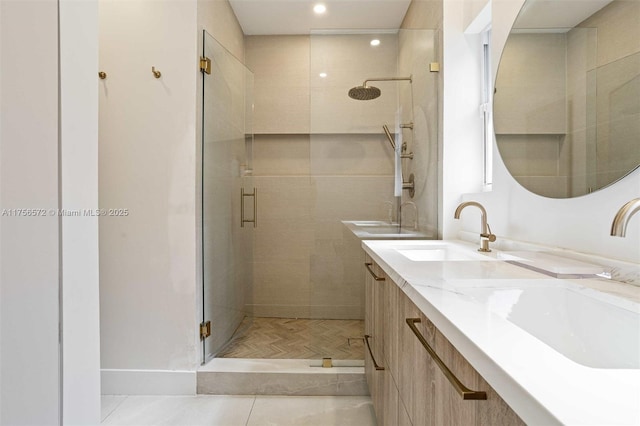 full bathroom with double vanity, a shower stall, and a sink