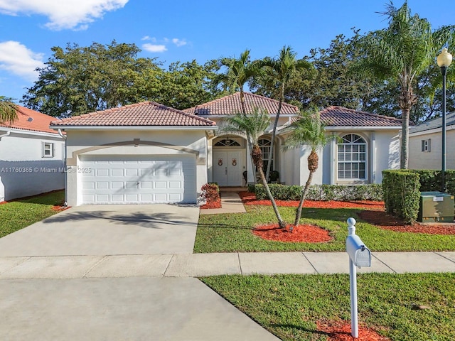 mediterranean / spanish-style house with stucco siding, a front lawn, concrete driveway, a garage, and a tiled roof