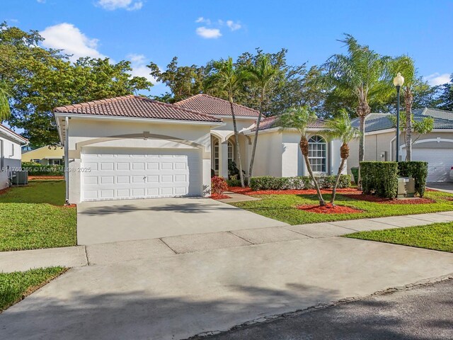 2430 SE 5th Ct, Homestead, FL 33033 - mediterranean / spanish house with a garage, a front yard, concrete driveway, stucco siding, and a tiled roof