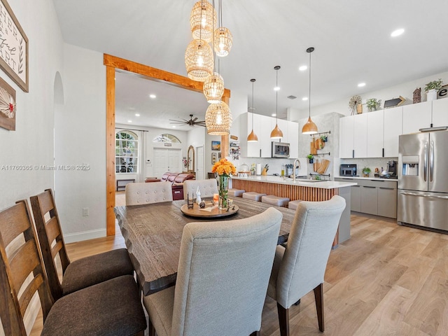 dining room featuring recessed lighting, light wood-type flooring, arched walkways, and ceiling fan