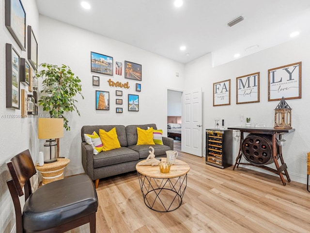 living room with a dry bar, recessed lighting, visible vents, and light wood finished floors