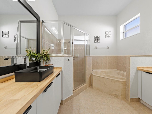 full bathroom featuring a bath, a shower stall, tile patterned floors, and vanity