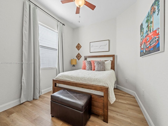 bedroom with light wood-style flooring, baseboards, and ceiling fan