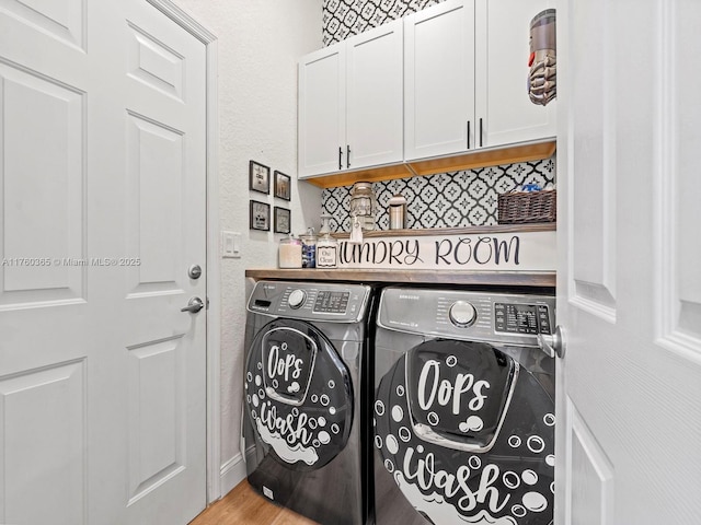 laundry room with cabinet space, independent washer and dryer, and wood finished floors