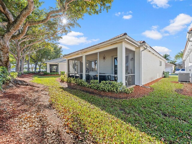 2430 SE 5th Ct, Homestead, FL 33033 - view of side of home featuring a sunroom, stucco siding, and a yard