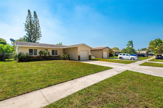 single story home with stucco siding, a front yard, an attached garage, and driveway