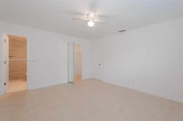 unfurnished room with light tile patterned floors, visible vents, ceiling fan, and baseboards