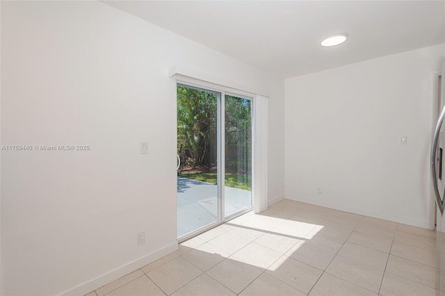 spare room with light tile patterned flooring and baseboards