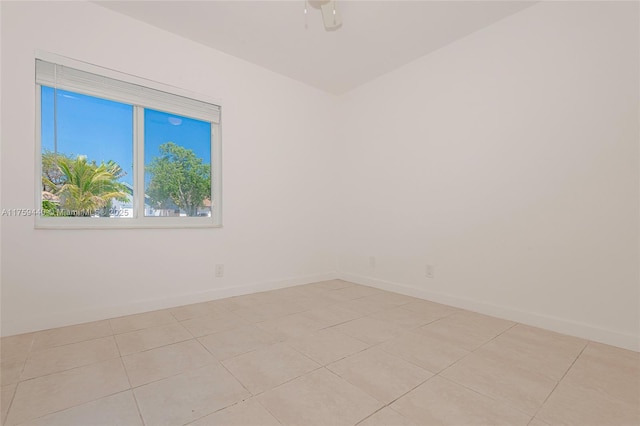 unfurnished room with light tile patterned floors, ceiling fan, and baseboards