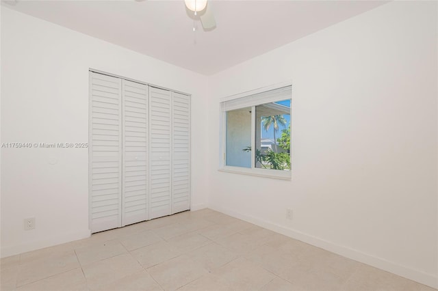 unfurnished bedroom featuring a closet, ceiling fan, baseboards, and light tile patterned flooring