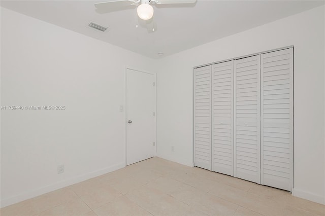 unfurnished bedroom with light tile patterned floors, a ceiling fan, visible vents, baseboards, and a closet