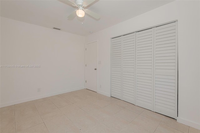 unfurnished bedroom featuring light tile patterned floors, a ceiling fan, baseboards, visible vents, and a closet