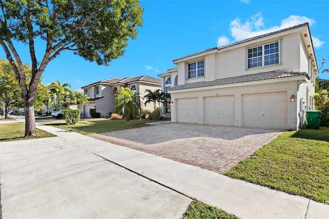 view of front facade featuring an attached garage, stucco siding, a front lawn, a tiled roof, and decorative driveway