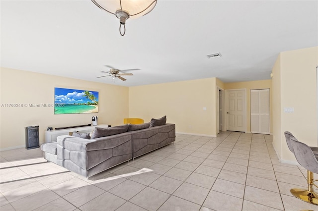 living room featuring light tile patterned floors, visible vents, a ceiling fan, and baseboards