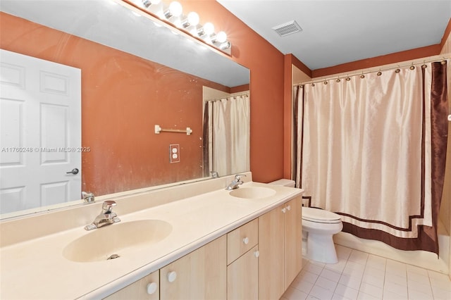 bathroom featuring double vanity, visible vents, toilet, and a sink