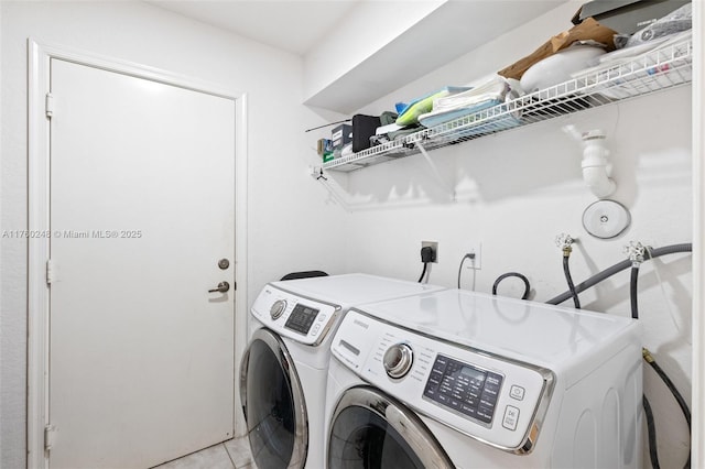 laundry area with washer and dryer, light tile patterned flooring, and laundry area