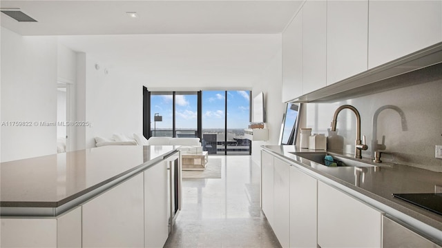 88 SW 7th St Unit 2208, Miami, FL 33130 - kitchen featuring white cabinetry, open floor plan, modern cabinets, black electric cooktop, and a center island