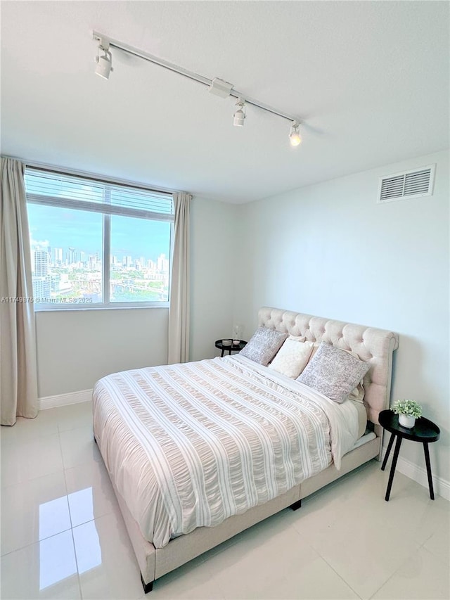 bedroom with tile patterned floors, visible vents, and baseboards