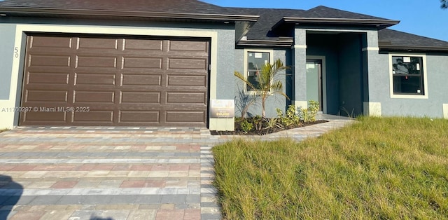 view of front of house with stucco siding and a shingled roof