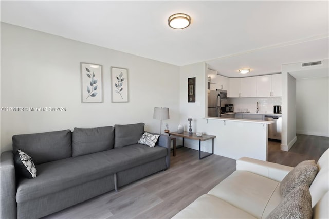 living room with light wood-style flooring and visible vents