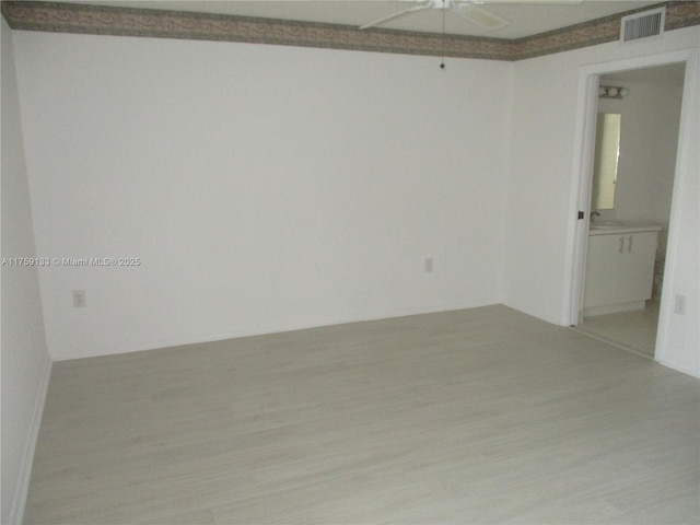 empty room with a ceiling fan, wood finished floors, and visible vents