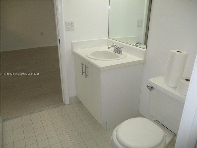 half bath featuring vanity, toilet, and tile patterned flooring