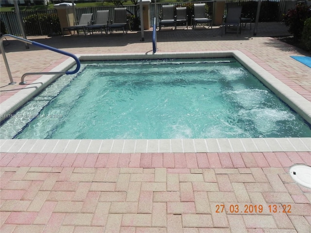 view of pool with a patio, a pool, and fence