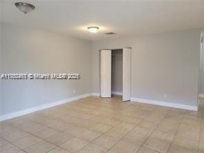 empty room featuring light tile patterned floors and baseboards