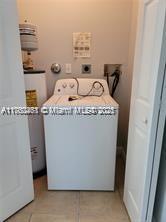 laundry room featuring water heater and washer / dryer